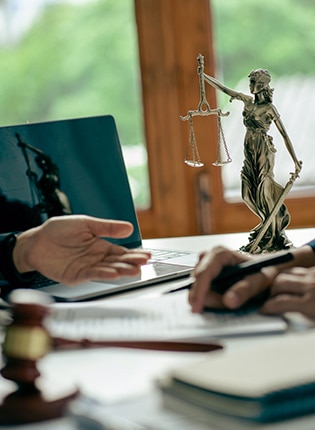 Lawyer Sitting at His Desk With Scales of Justice