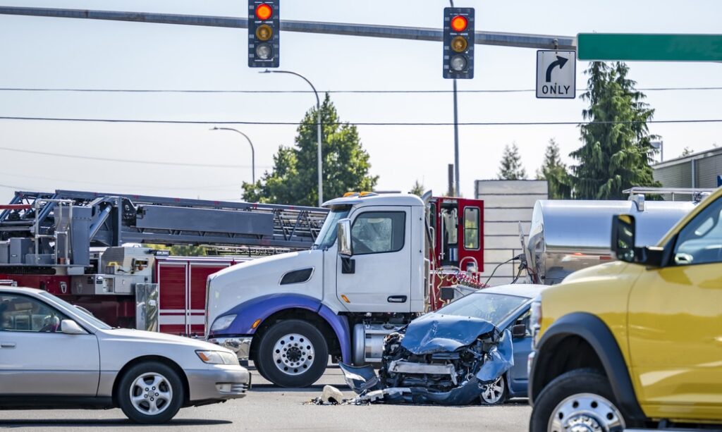 Damaged cars after a car accident crash involving a big rig semi truck with semi trailer at a Boonville Intersection